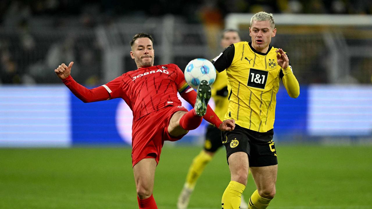 Freiburgs Christian Günter und Dortmunds Julian Ryerson kämpfen um den Ball |  INA FASSBENDER / AFP