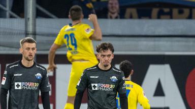 Sebastian Klaas (l) und Paderborns Aaron Zehnter sind enttäuscht, während im Hintergrund Braunschweigs Hasan Kurucay nach seinem Tor zum 0:1 jubelt.