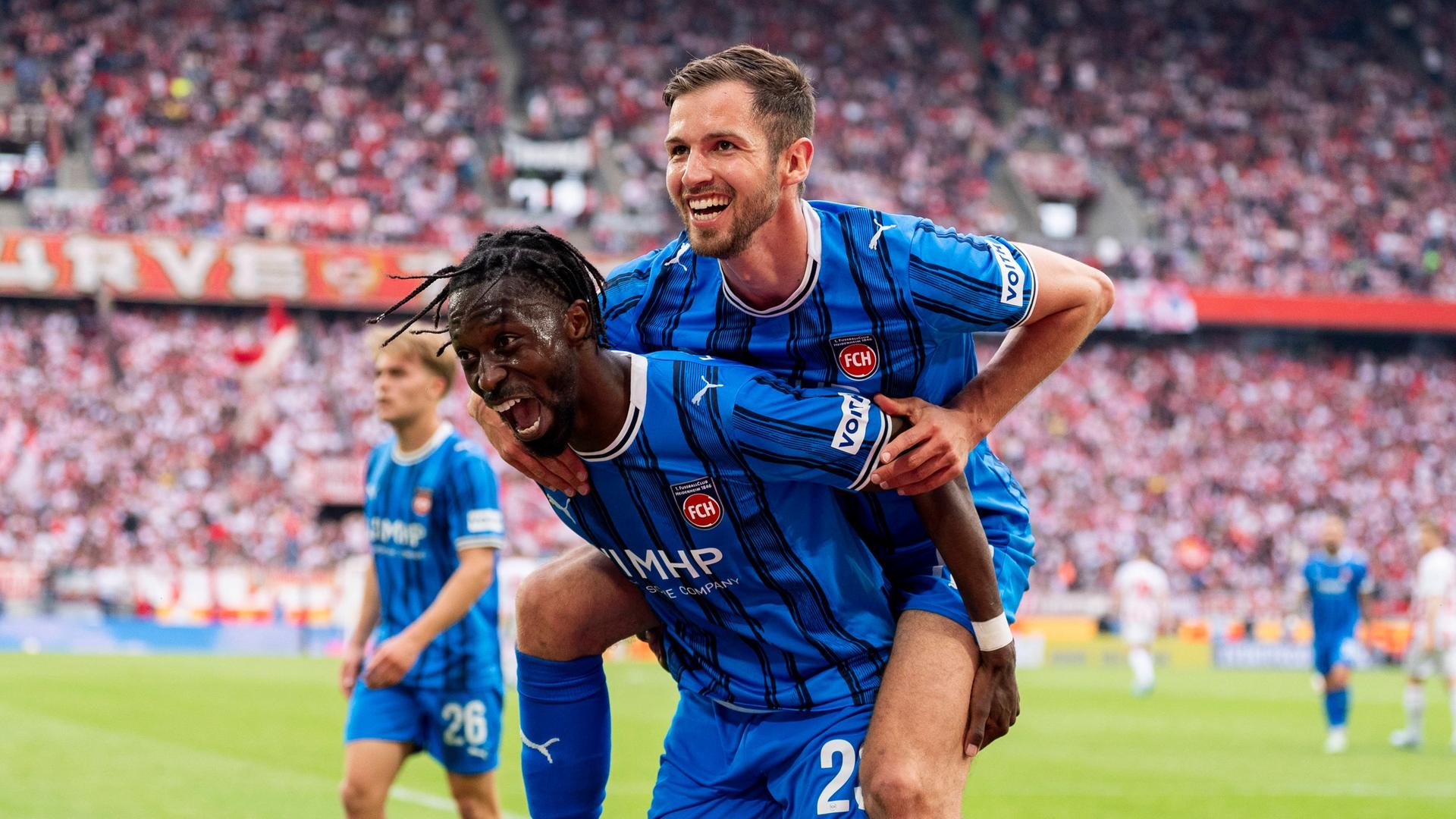 Die Heidenheimer Omar Traore (u.) und Marvin Pieringer (o.) bejubeln einen Treffer in Köln | IMAGO / HMB-Media
