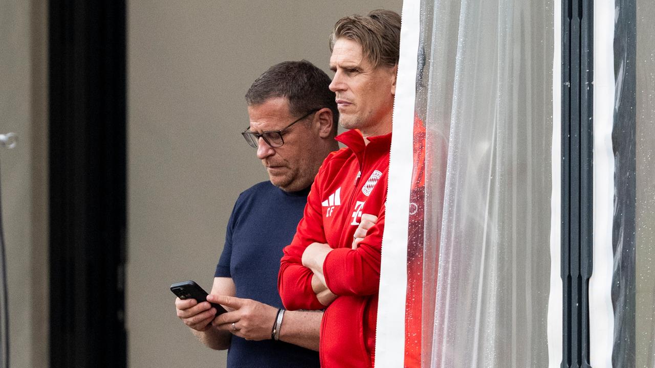 Trainingslager von Bayern München, Saison 2023/2024 in Rottach-Egern: Sportvorstand Max Eberl (l.) und Münchens Sportdirektor Christoph Freund beobachten das Training. Eberl schaut aufs Handy. | picture alliance / Kirchner-Media | Kirchner/David Inderlied