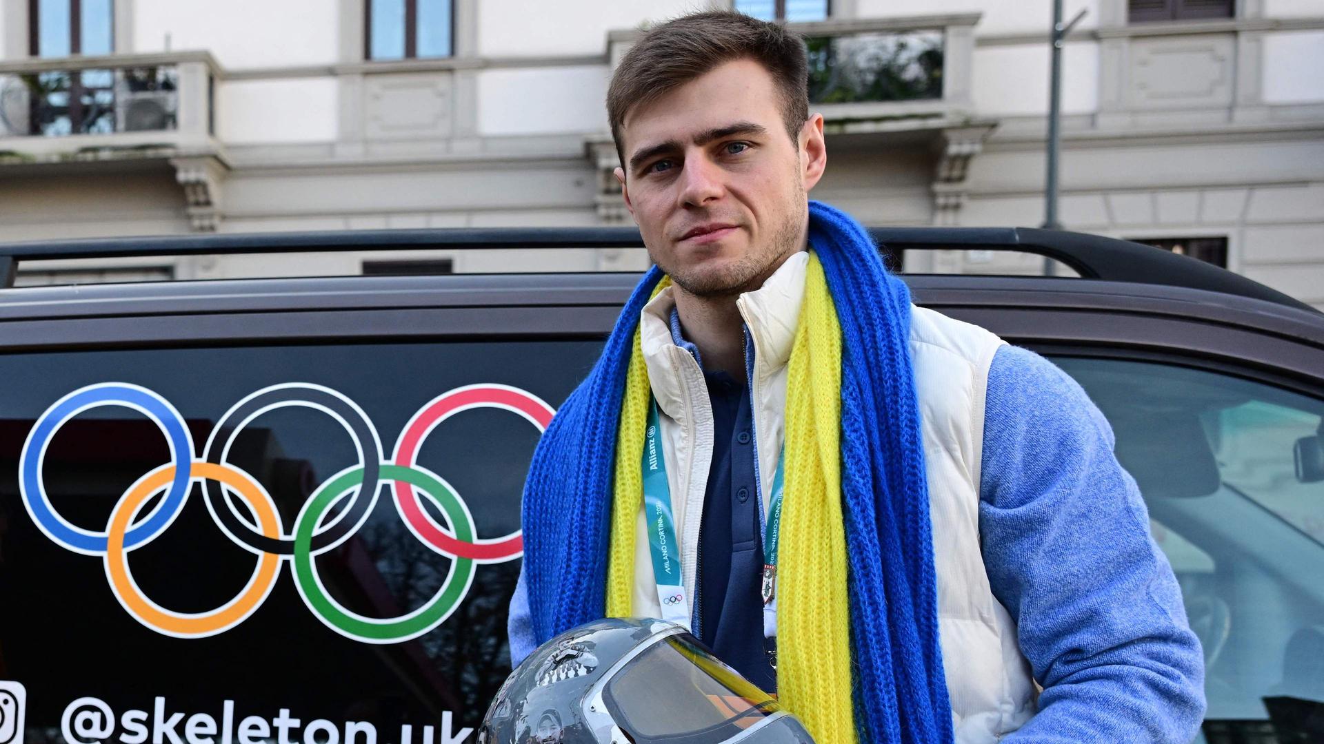 Vladyslav Heraskevych mit seinem Helm bei der Pressekonferenz. | AFP / PIERO CRUCIATTI