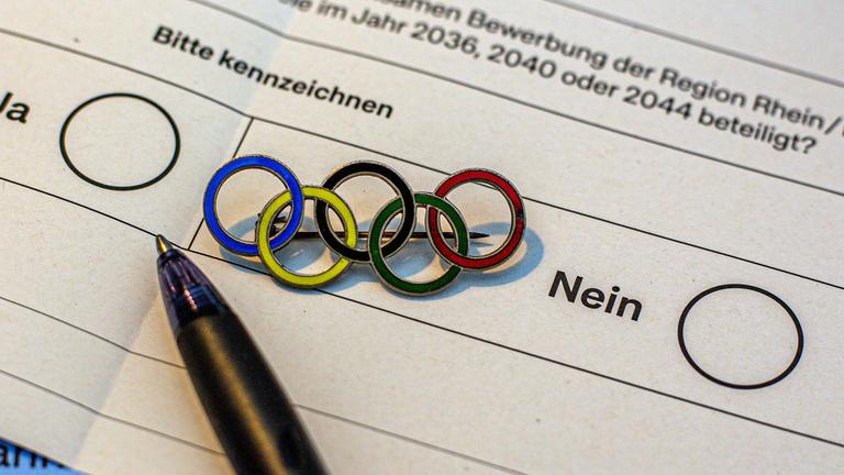 Unterlagen zur Abstimmung über die Olympischen Spiele in Köln und der Region Rhein/Ruhr liegen auf einem Tisch.