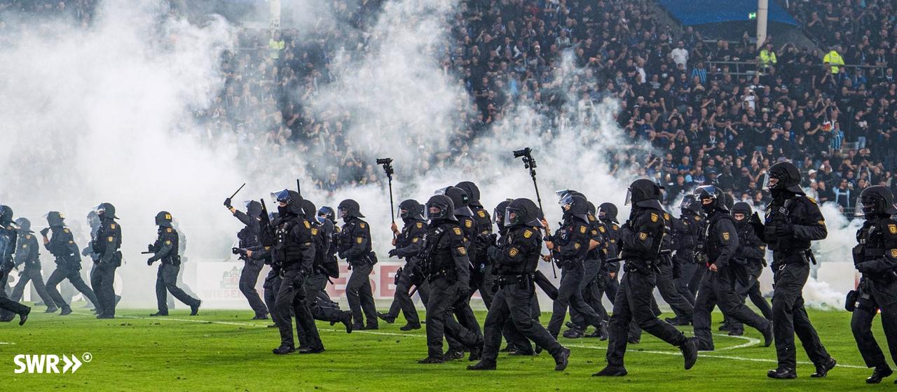 Polizisten stürmen auf den Rasen im Stadion von Waldhof Mannheim