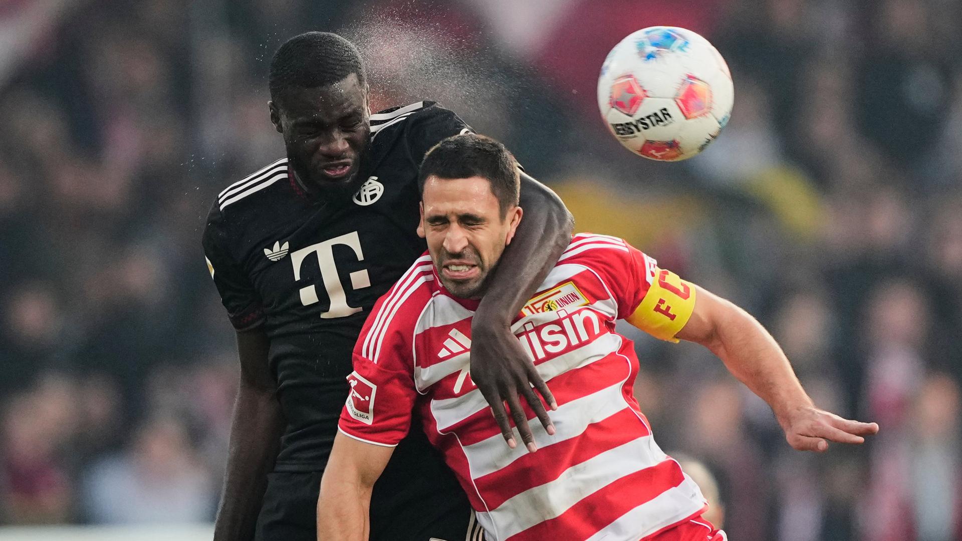 Fußballprofi Dayot Upamecano (l.) vom FC Bayern München im Kopfballduell mit Rani Khedira von Union Berlin | AP/Meissner