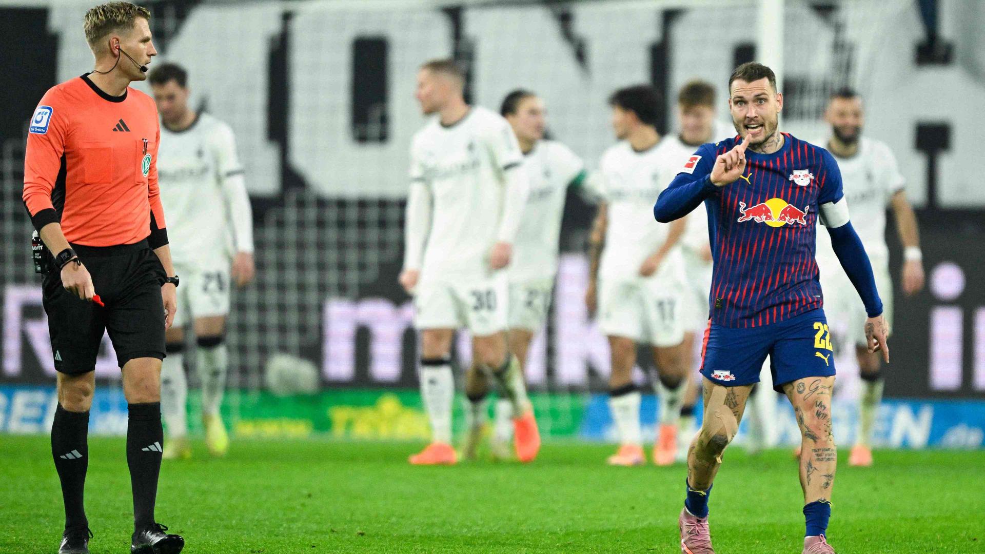 Timo Gerach (l.), David Raum (Leipzig) und mehrere Gladbacher im Hintergrund | AFP/INA FASSBENDER