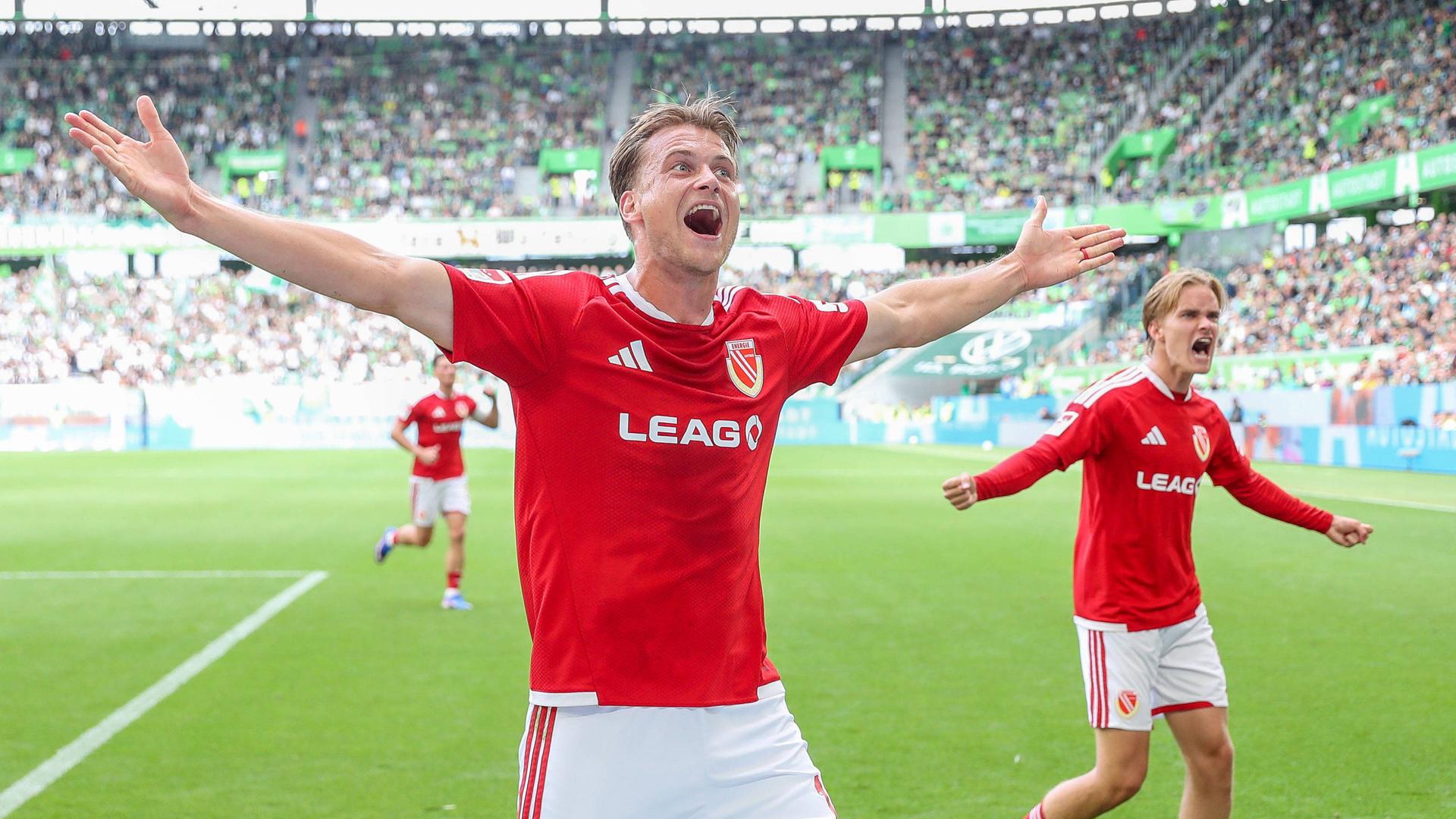 Die Spieler von Energie Cottbus bejubeln den Ausgleichstreffer in Wolfsburg | IMAGO/Jan Huebner