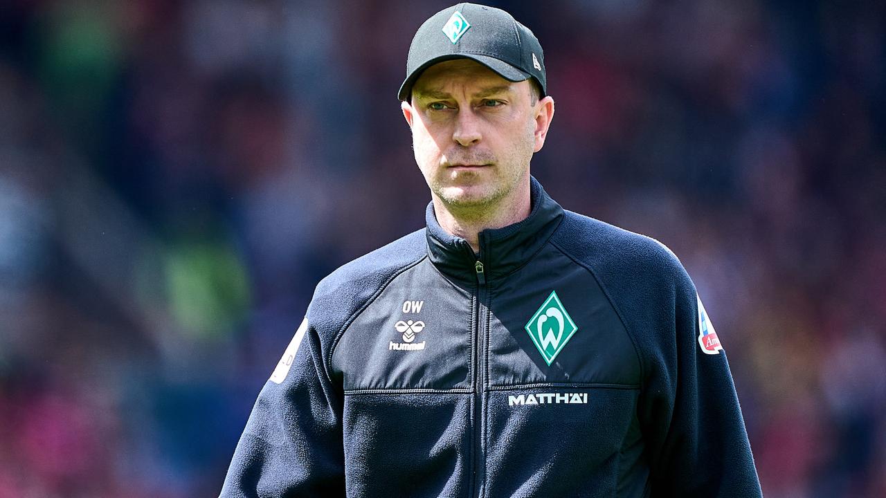 Werder-Trainer Ole Werner geht mit schwarzer Kappe auf dem Kopf konzentriert zu seiner Trainerbank vor einem Spiel. | Gumzmedia | Andreas Gumz
