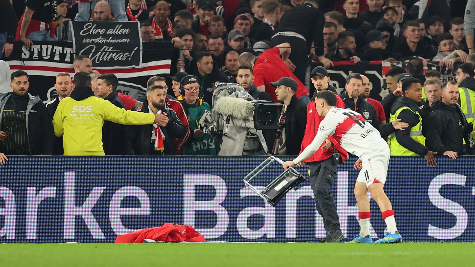 Bilal El Khannouss del Stuttgart con una silla lanzada por los aficionados al campo de juego