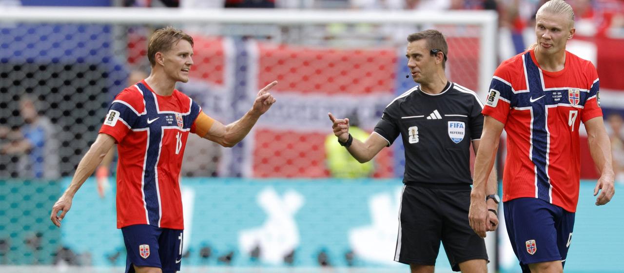 Clement Turpin spricht mit Norwegens Kapitän Martin Ödegaard