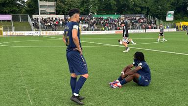 Spieler der SV Hemelingen sind frustriert nach dem Spiel gegen den Heider SV. Einige sitzen auf dem Platz und schauen traurig.