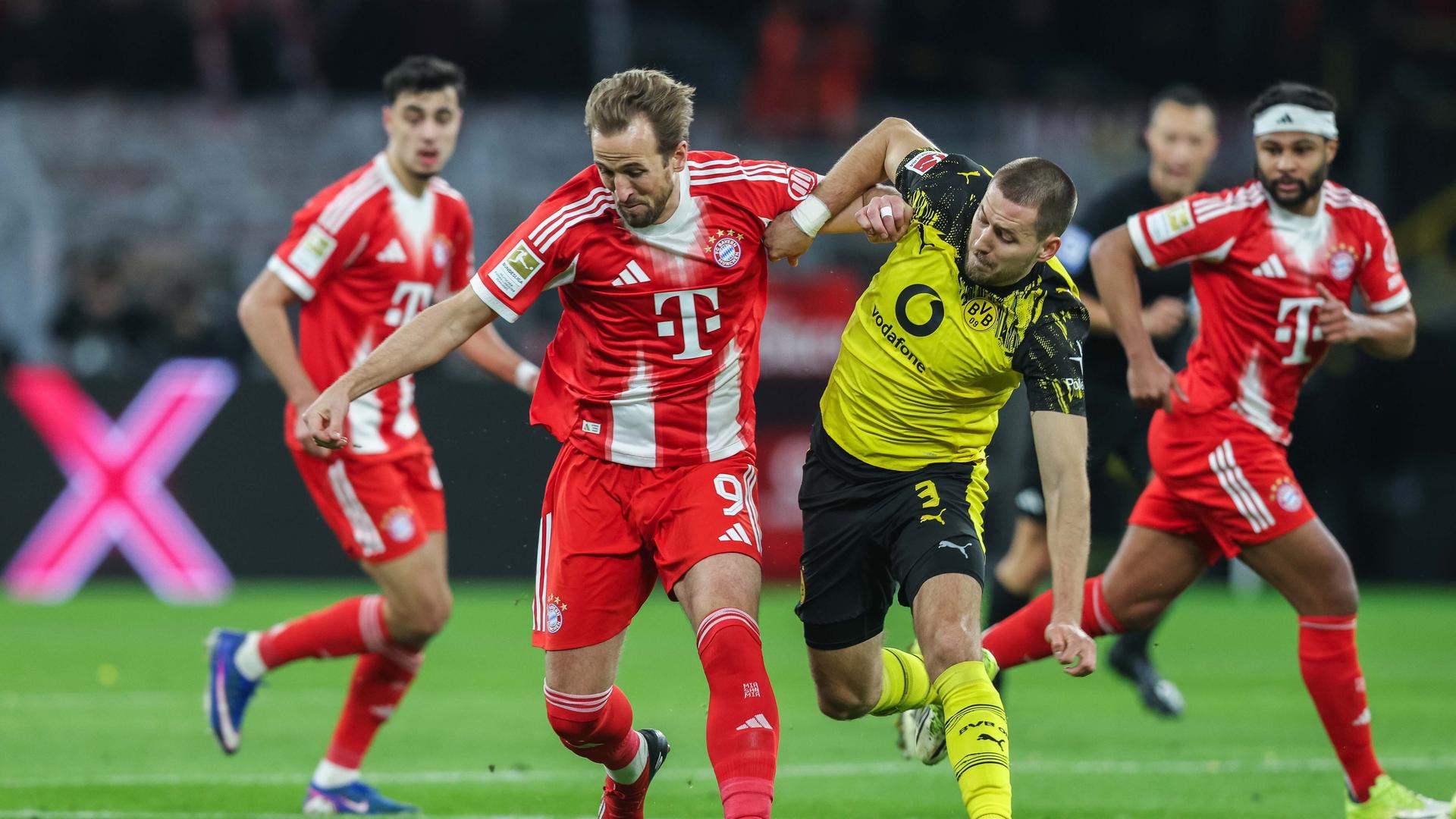 Bayern's Harry Kane in a duel with Dortmund's Waldemar Anton