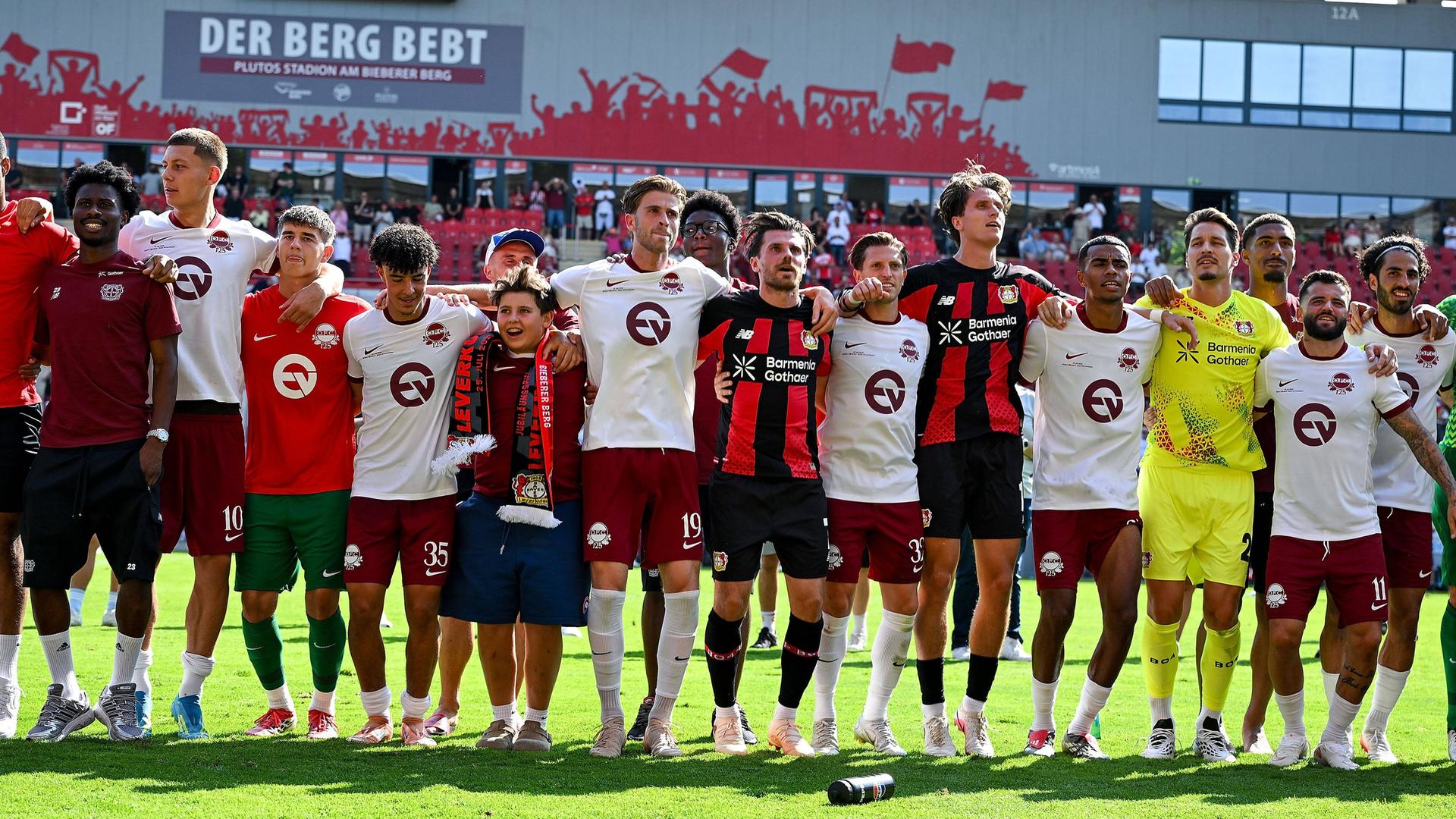 Arm in Arm: Offenbacher und Leverkusener Fußballer nach dem Abpfiff. | IMAGO