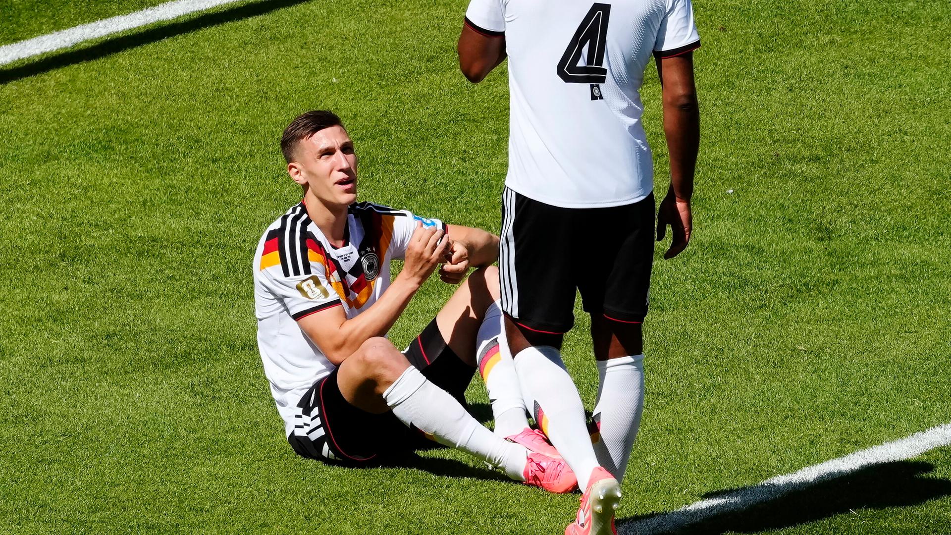 Deutschlands Nico Schlotterbeck (l.) sitzt verletzt am Boden | ddp/ZUMA