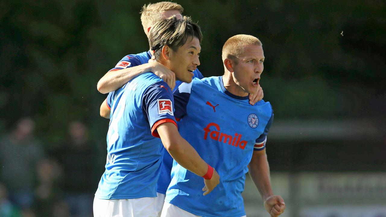 Shuto Machino (l.) und Lewis Holtby feiern ein Tor. | IMAGO / Claus Bergmann