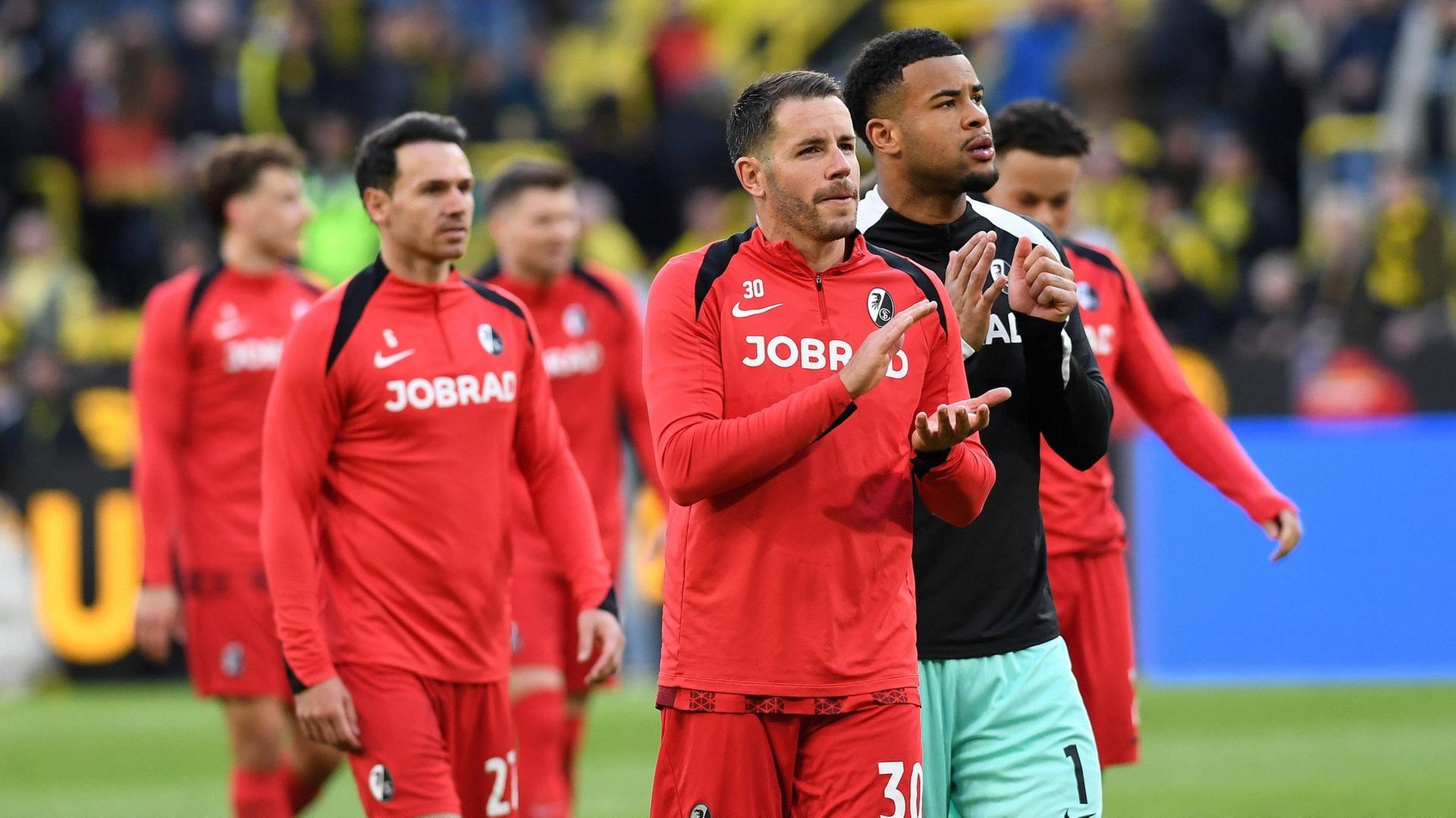 Christian Guenter (SC Freiburg) und Torwart Noah Atubolu (SC Freiburg) applaudieren nach dem Bundesligaspiel zwischen Borussia Dortmund und Club Freiburg. | IMAGO, IMAGO / DeFodi Images