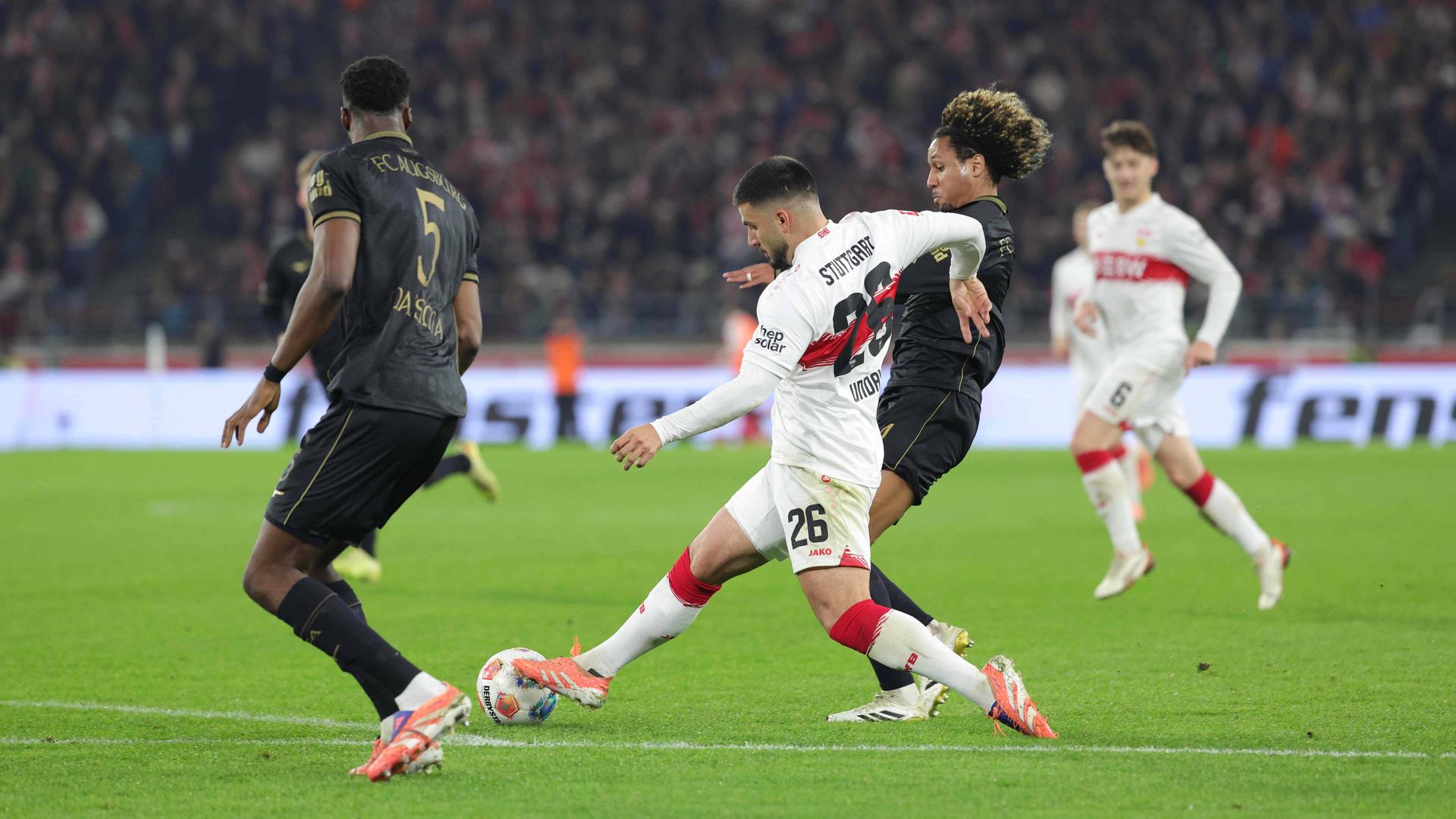 Stuttgarts Deniz Undav (m.) versucht sich gegen zwei Augsburger durchzusetzen | IMAGO/Volker Mueller