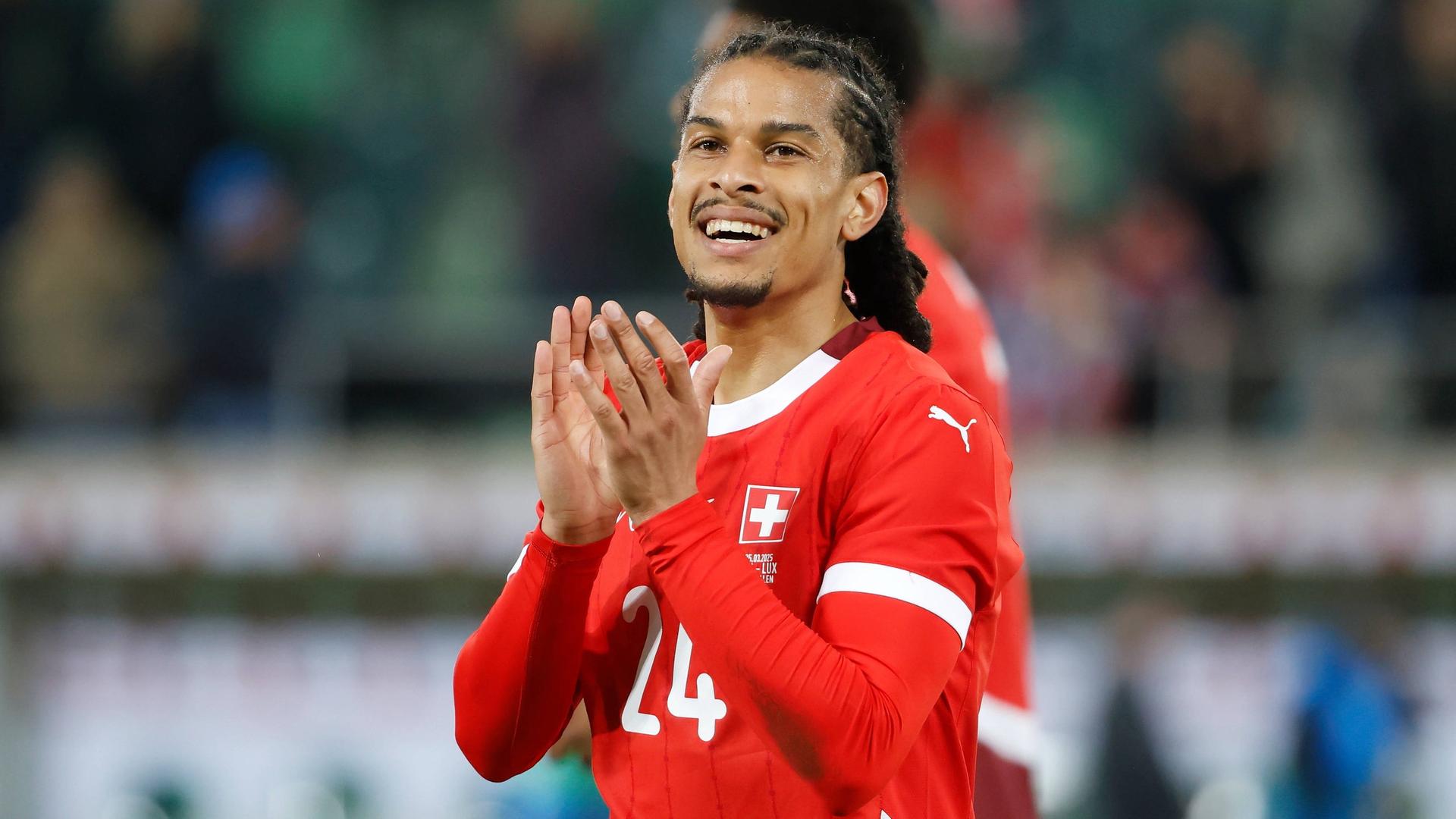 Der Schweizer Nationalspieler Isaac Schmidt lacht und applaudiert. | Imago | Manuel Stefan