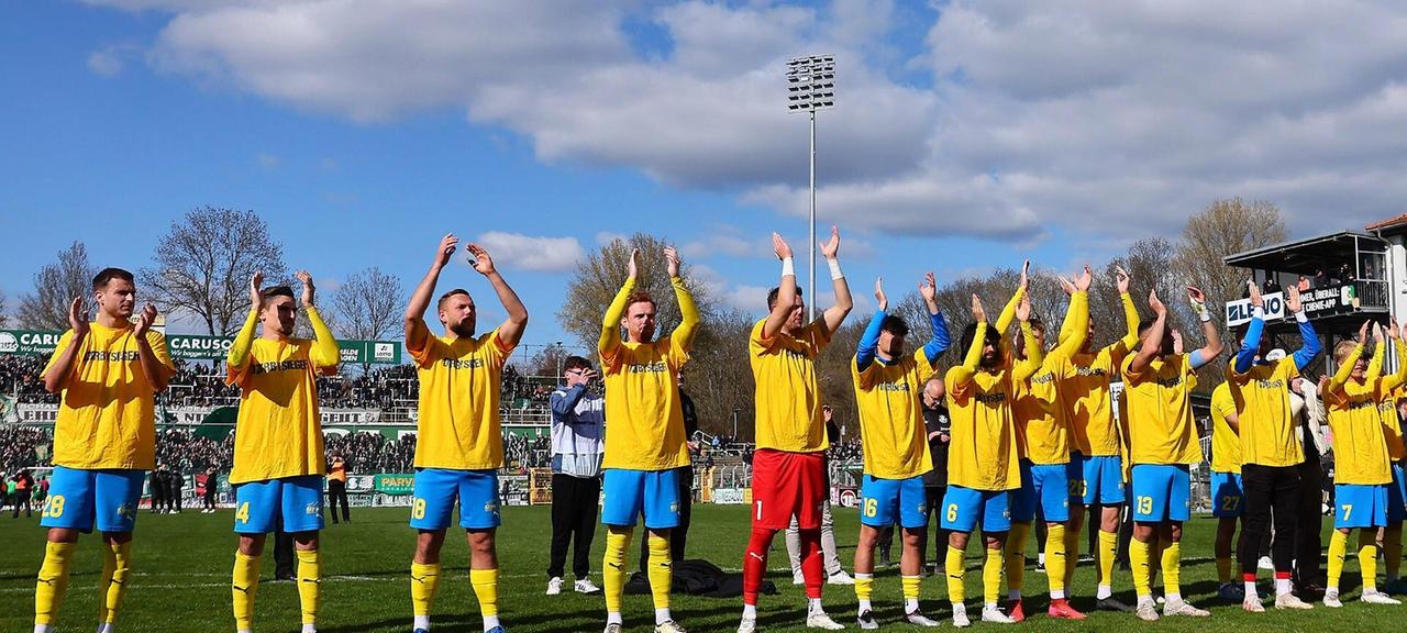 Die Spieler von Lok Leipzig jubeln mit den Fans