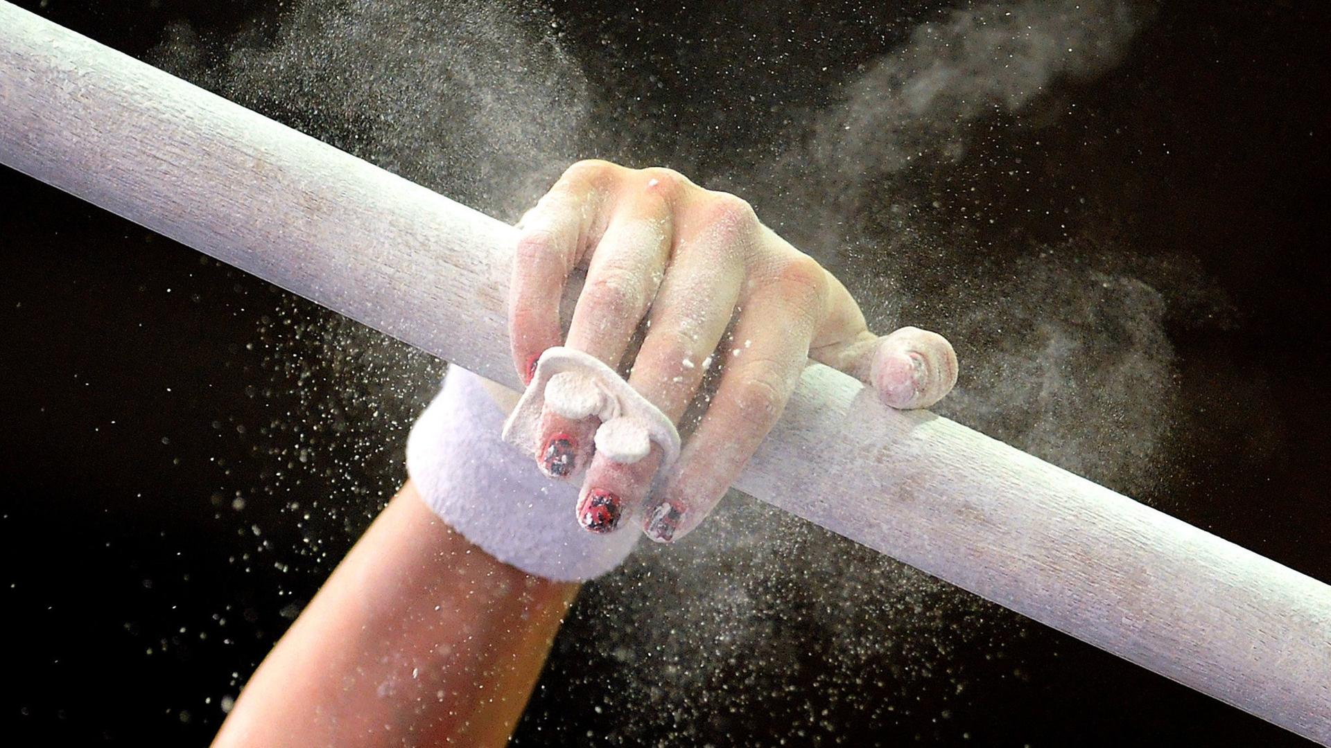 Die Hand einer Turnerin greift nach dem Holm | WDR/dpa/Michael Hanschke