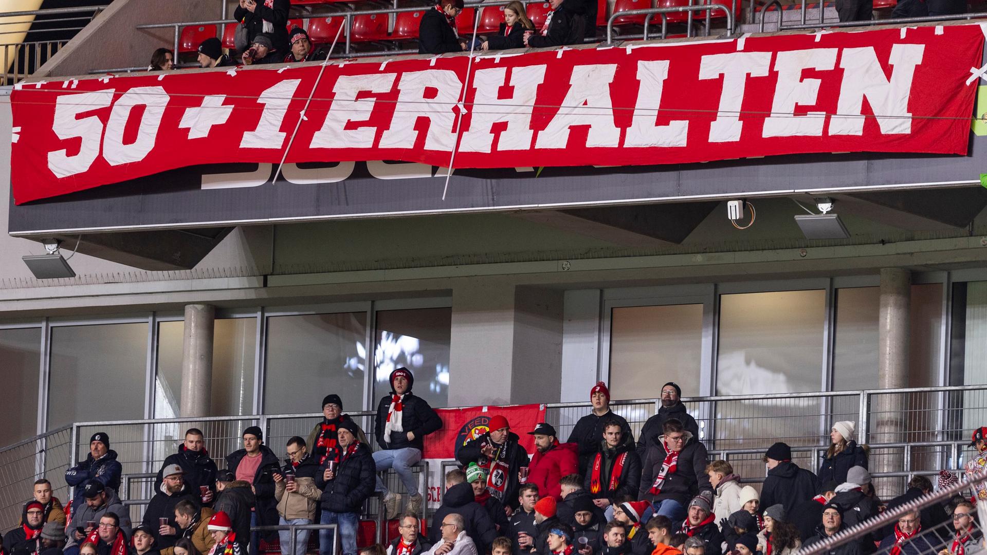 Fans des SC Freiburg mit einem Banner für 50+1 bei einem Spiel im Dezember 2024 in Leverkusen | ddp/Sven Simon