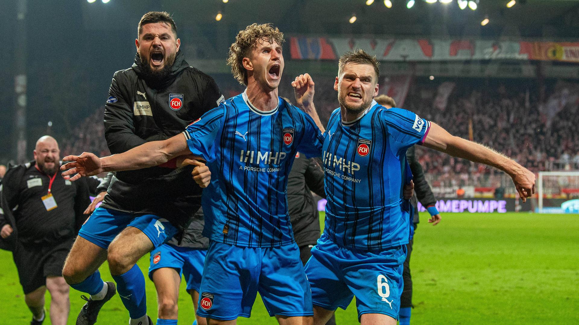 Heidenheims Spieler um Torschützen Jan Schöppner (v. m.) bejubeln den Last-Minute-Siegtreffer in Berlin | IMAGO / Matthias Koch