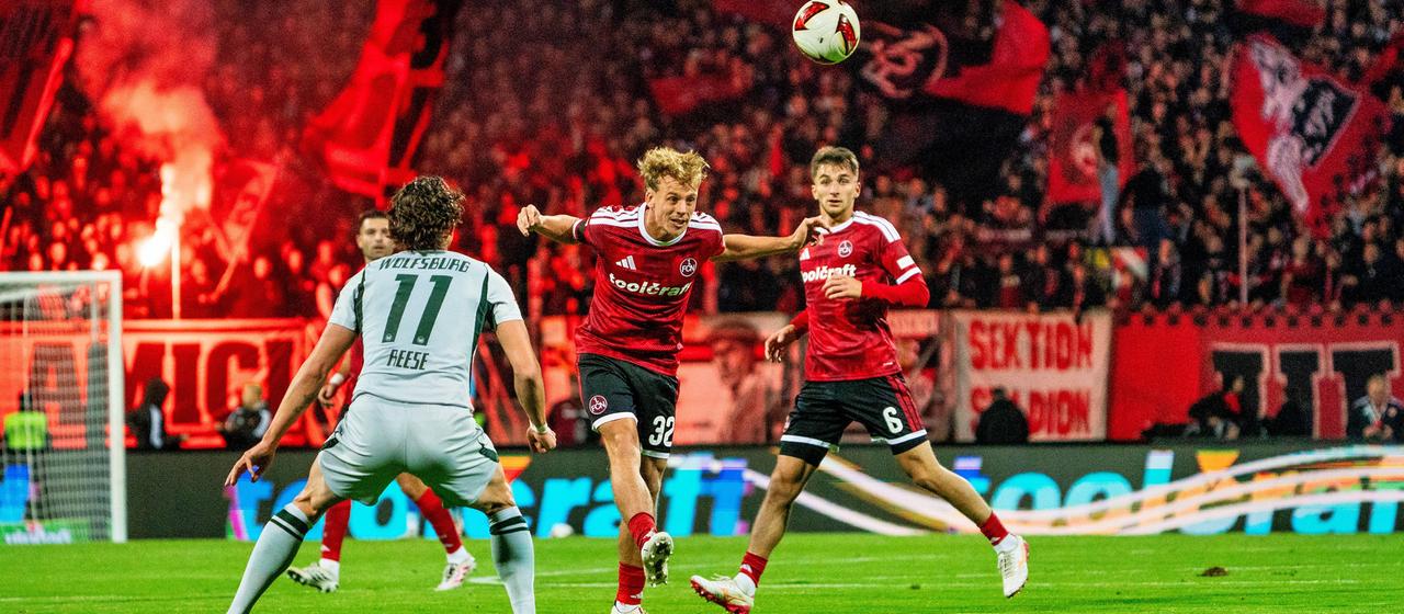 Nürnbergs Tim Janisch ist vor Fabian Reese vom VfL Wolfsburg am Ball