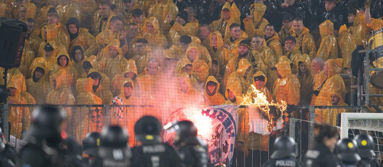 Polizisten stehen während einer Spielunterbrechung im Stadion vor dem K-Block mit Dresdner Fans