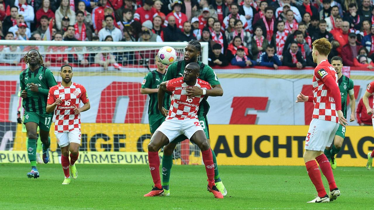 Josuha Guilavogui von Mainz 05 im Zweikampf mit Gladbachs Jordan Siebatcheu | IMAGO/Norbert Jansen / fohlenfoto