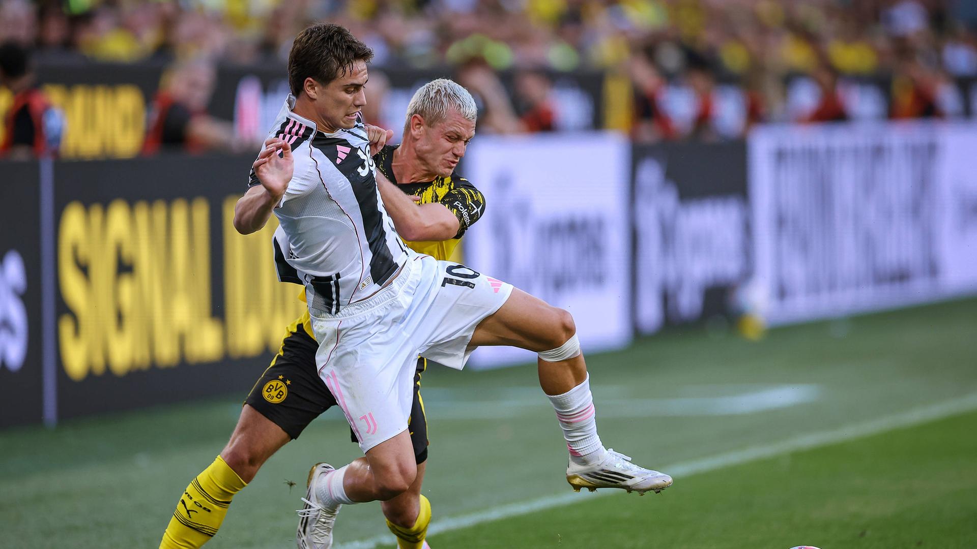 Dortmunds Julian Ryerson (hinten) im Duell mit Kenan Yildiz von Juventus Turin. | IMAGO / Maximilian Koch