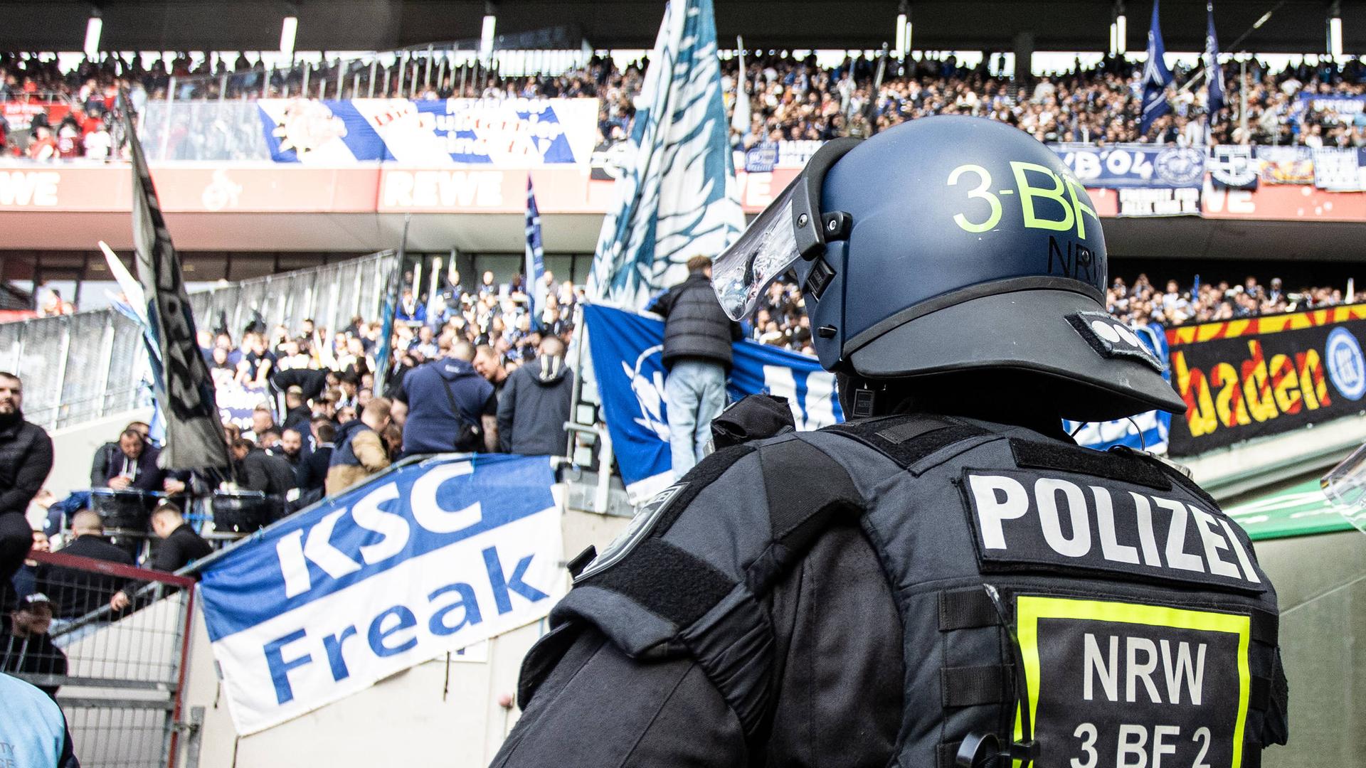 Ein Polizist im Stadion des 1. FC Köln vor Fans des Karlsruher SC | Imago
