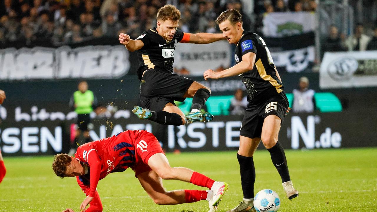 Wanner (1. FC Heidenheim, 10), Robin Fellhauer (SV Elversberg, 06) und Lukas Petkov (SV Elversberg, 25) im Kampf um den Ball ,  | IMAGO / Steinsiek.ch