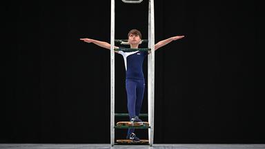 Ein junger Turner turnt mit einem Rhönrad während des Turnfests in Leipzig. 