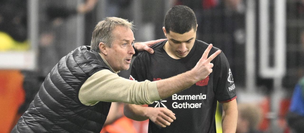 Leverkusen-Trainer Kasper Hjulmand spricht am Spielfeldrand mit Ibrahim Maza