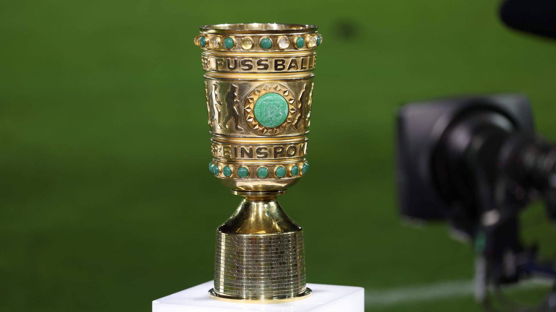 Der DFB-Pokal steht am Spielfeldrand mit einer TV-Kamera davor | dpa/Friso Gentsch