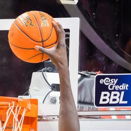 Ein Spieler dunkt, wobei das Logo der BBL zu sehen ist