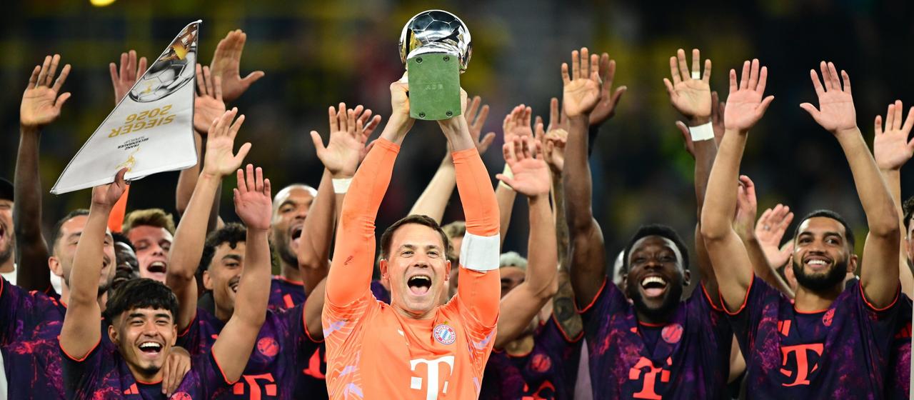 Manuel Neuer (v.) und die Spieler des FC Bayern München bejubeln den Gewinn des Supercups mit der Trophäe
