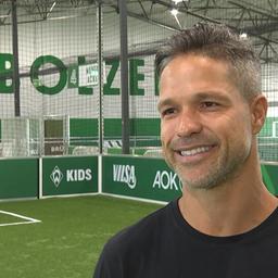 Werders ehemaliger Spieler Diego steht lächelnd in Werders Fußballhalle bei einem Interview.