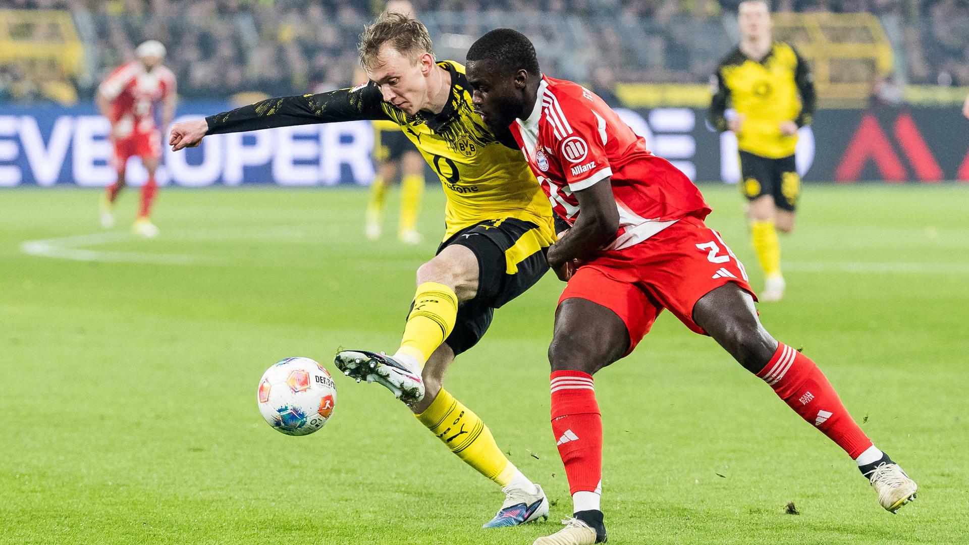 Fußballprofi Maximilian Beier (l., Borussia Dortmund) im Zweikampf mit Dayot Upamecano von Bayern München | imago/Beautiful Sports/Wunderl