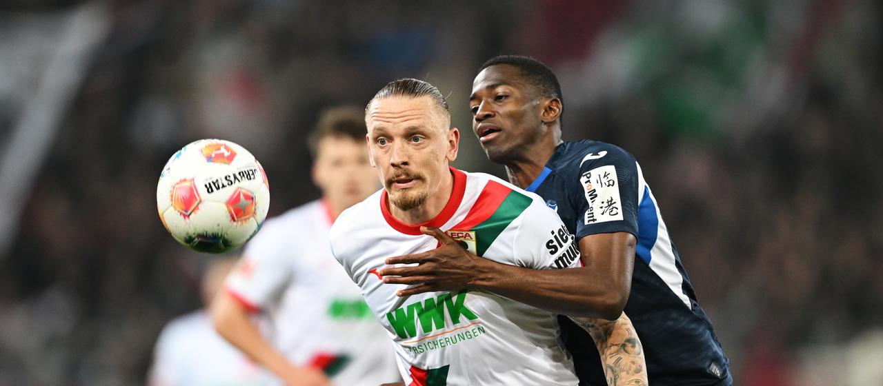 Augsburgs Marius Wolf im Zweikampf mit Hoffenheims Bazoumana Toure