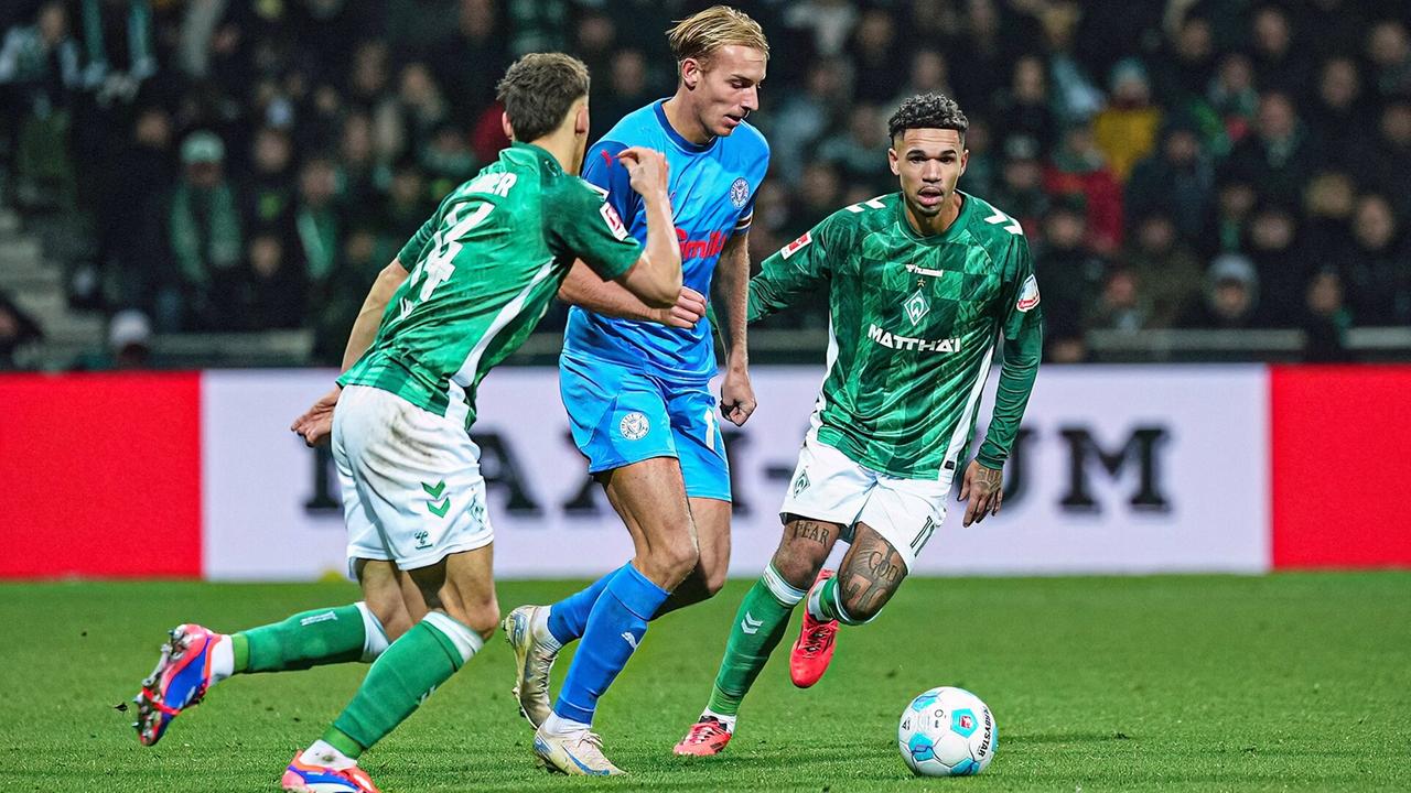 Kiels Timo Becker (m.) im Zweikampf mit Bremens Milos Veljkovic (l). und Justin Njinmah | Imago Images