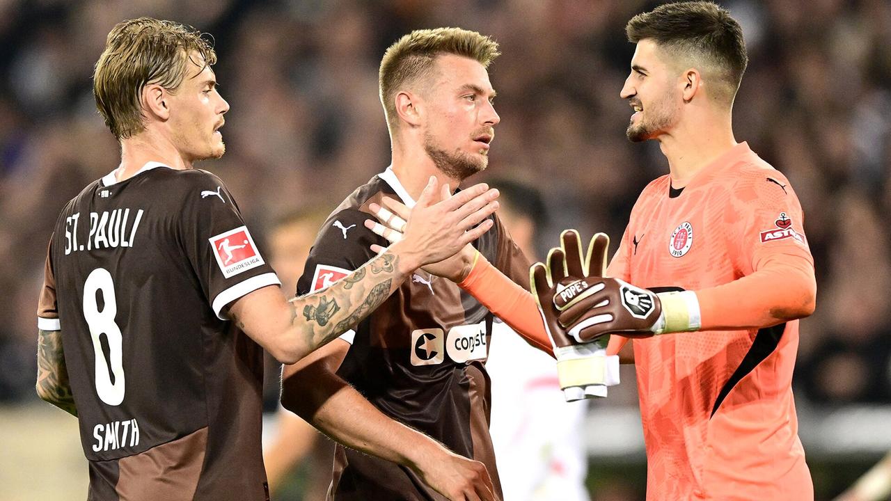 Die St.-Pauli-Profis Eric Smith (l.), Hauke Wahl und Torwart Nikola Vasilj (r.) | Witters