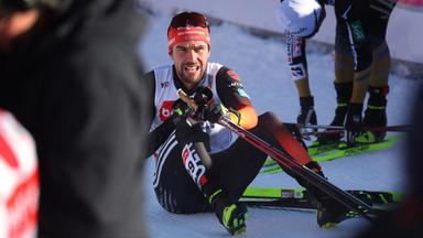 Johannes Rydzek sitzt erschöpft im Ziel