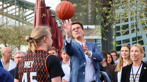 Hendrik Wüst spielt bei einem Olympia-PR-Termin Basketball