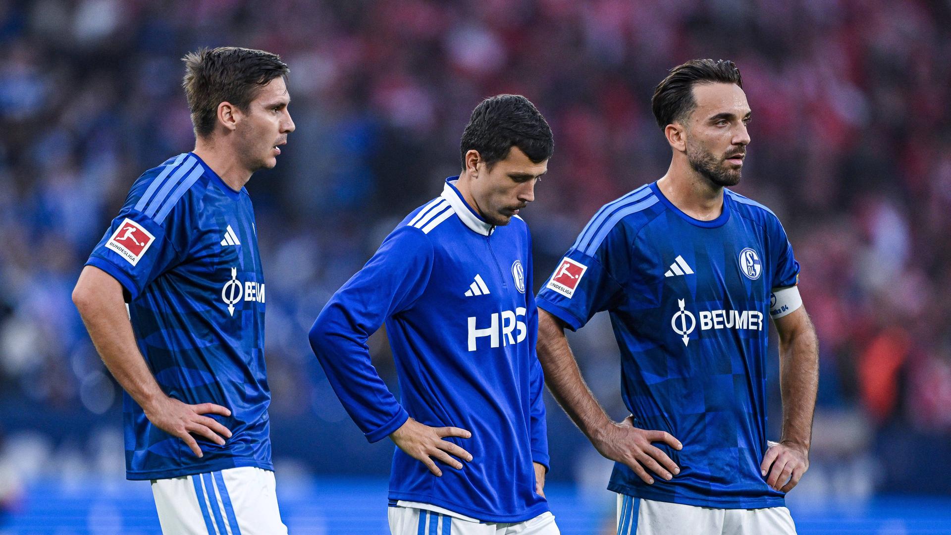Schalkes Maximilian Wöber (v.l.), Ron Schallenberg und Kenan Karaman stehen mit hängenden Köpfen vor den Fans | IMAGO/RHR-Foto