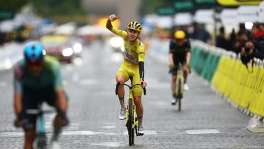 Tadej Pogacar fährt über die letzte Ziellinie der Tour de France und jubelt über seinen Gesamtsieg