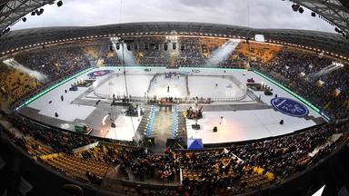 Stadionübersicht mit illuminierten Rängen.