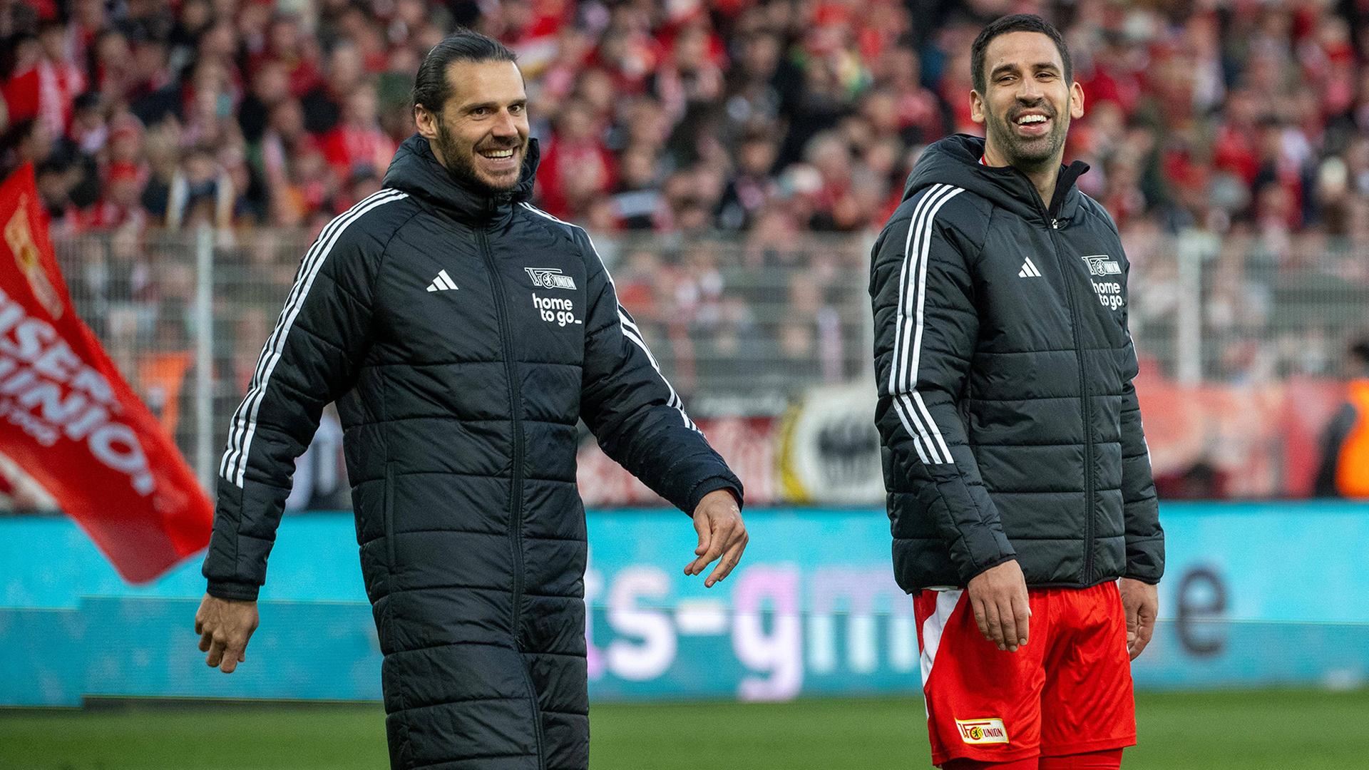 Union-Spieler Trimmel und Khedira laufen lachend über den Platz (Quelle: IMAGO / Matthias Koch) | IMAGO / Matthias Koch