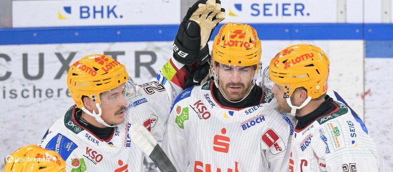 Der Eishockey-Profi Miha Verlic von den Fischtown Pinguins aus Bremerhaven wird von seinem Teamkollegen für ein Tor gefeiert.