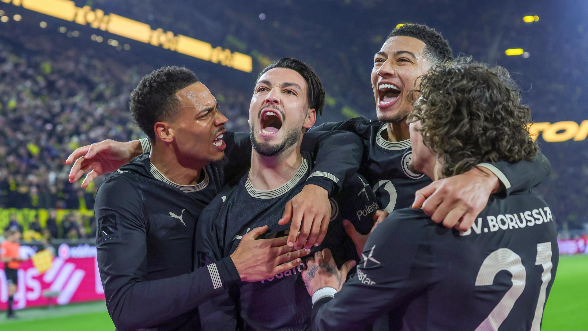 Рами Бенсебаини празднует свой гол с пенальти, сделавший счет 3:2, со своими товарищами по команде.